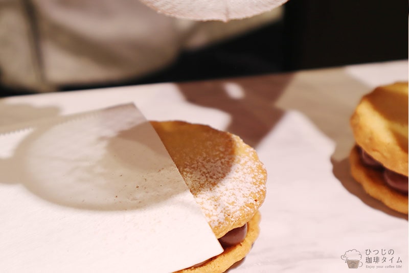 クッキーの半分に紙をのせ、粉糖をかける